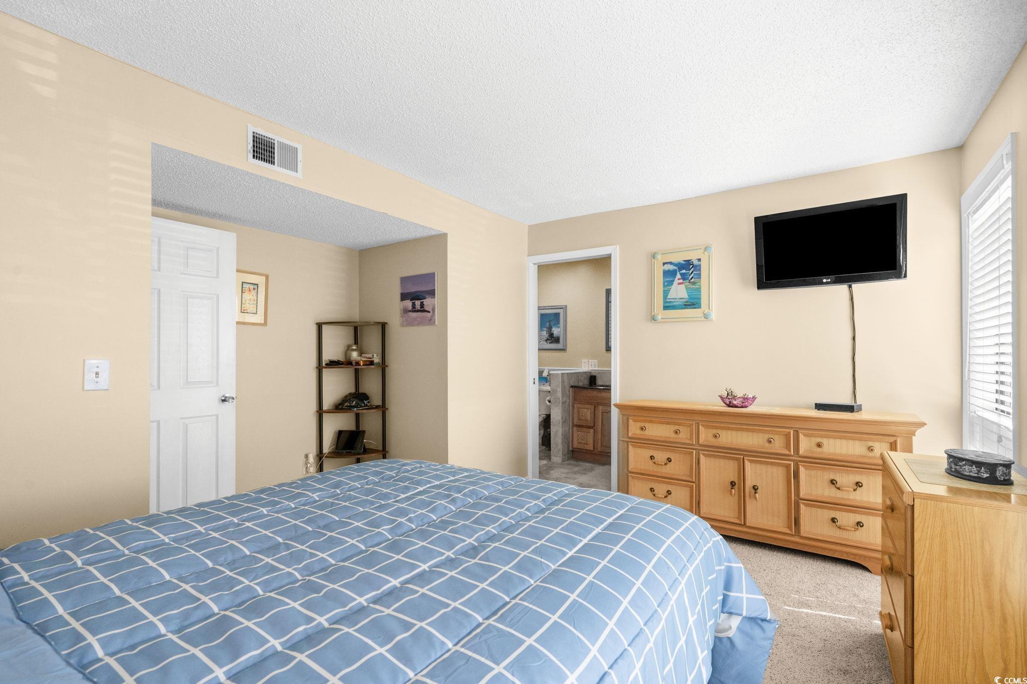 351 Lake Arrowhead Road, Unit 20179 Myrtle Beach, SC 29572 - Photo 20 of 40 Bedroom with a textured ceiling, light carpet, and ensuite bath
