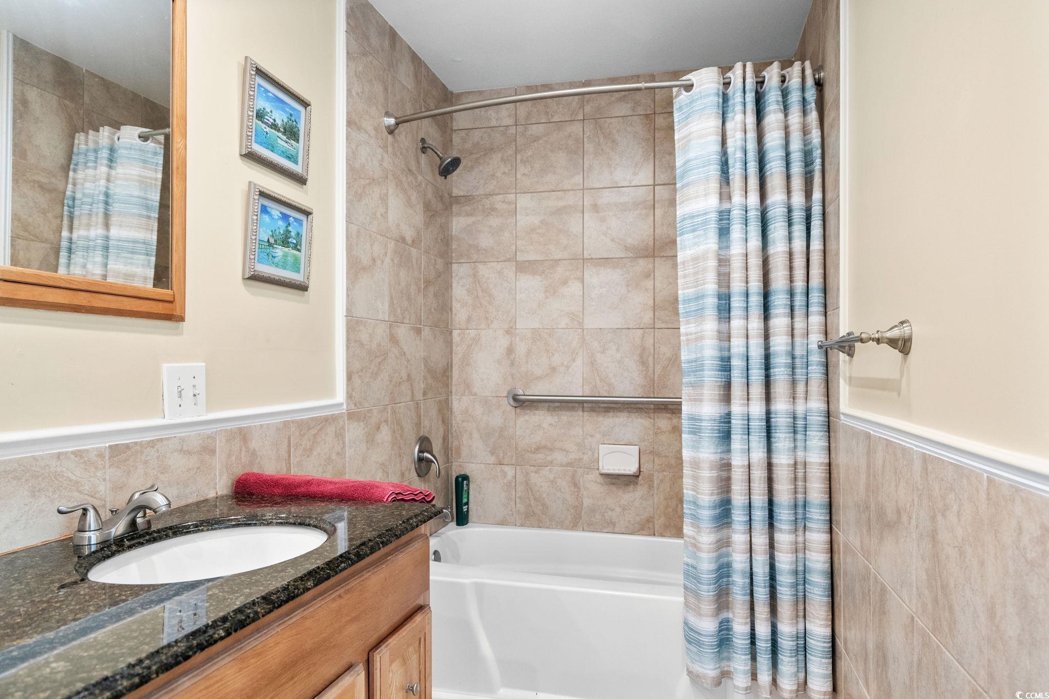 351 Lake Arrowhead Road, Unit 20179 Myrtle Beach, SC 29572 - Photo 22 of 40 Bathroom featuring shower / bath combo, vanity, tile walls, and wainscoting