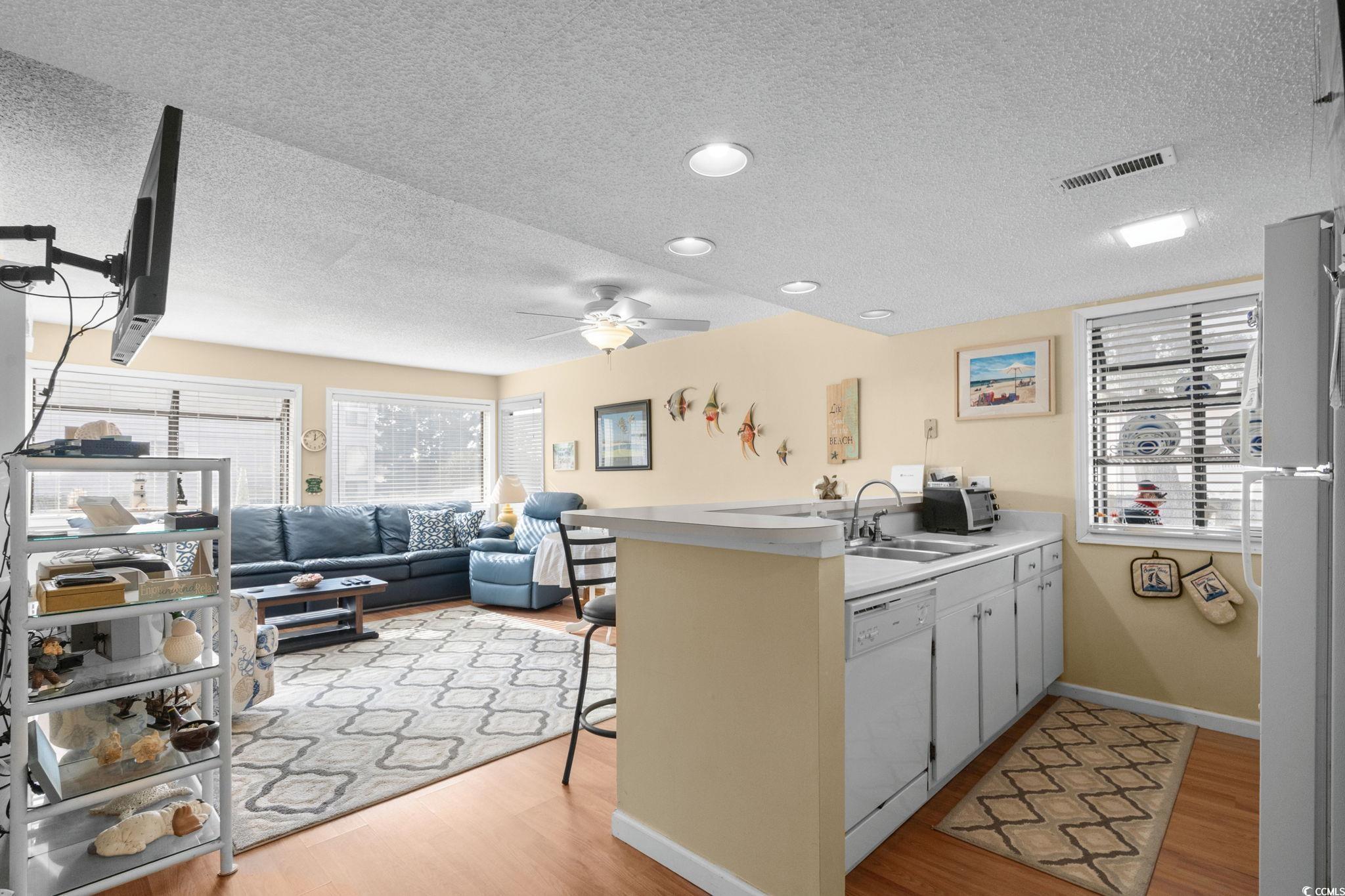 351 Lake Arrowhead Road, Unit 20179 Myrtle Beach, SC 29572 - Photo 7 of 40 Kitchen with light countertops, a breakfast bar area, white appliances, and a textured ceiling