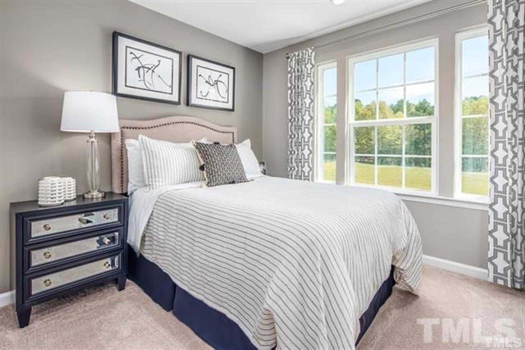 6615 Pathfinder Way, Unit 1054B Raleigh, NC 27616 - Photo 7 of 8 a bedroom with a bed and a lamp on dresser