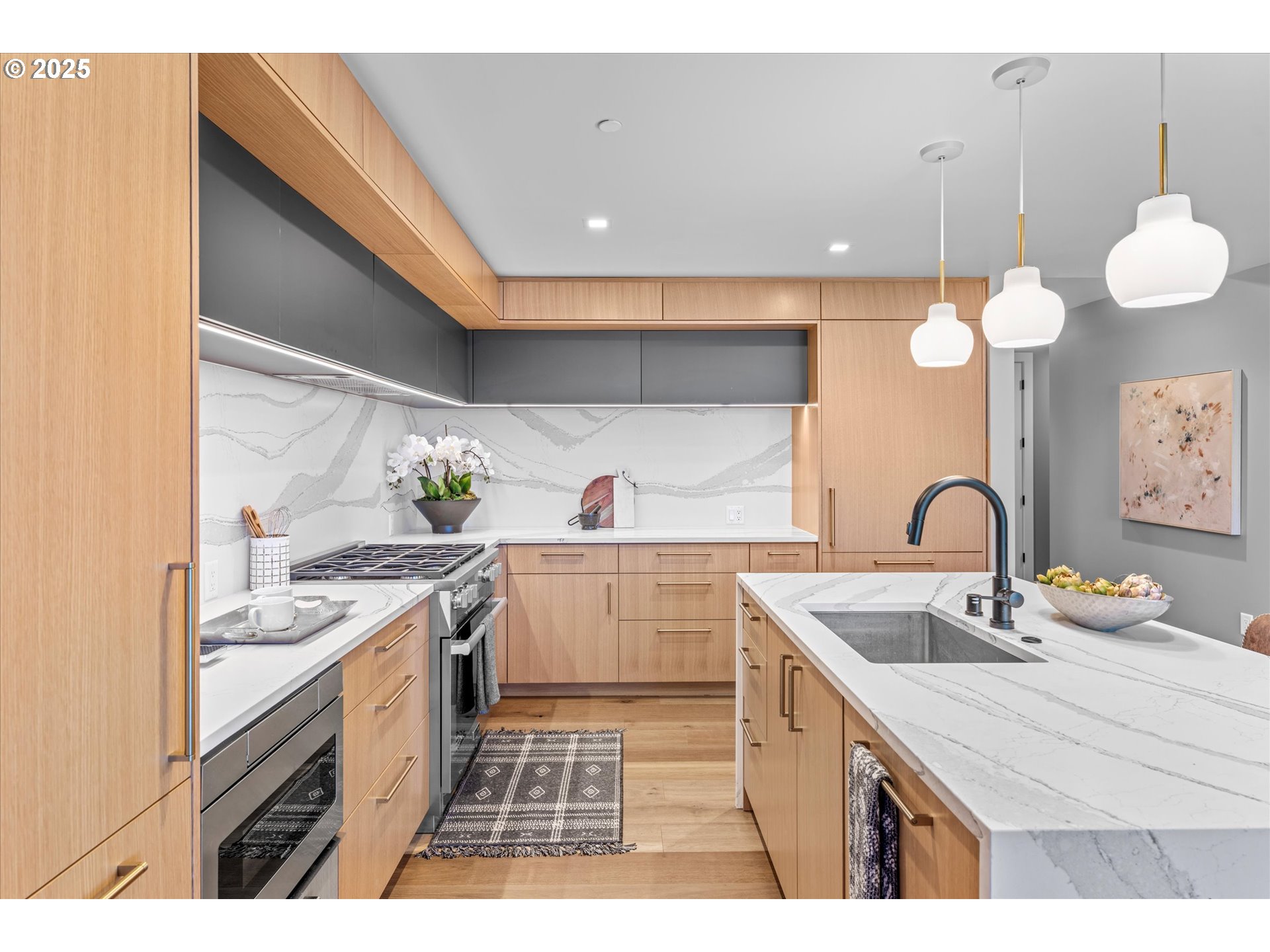 590 Waterfront Way, Unit 700 Vancouver, WA 98660 - Photo 4 of 35 a kitchen with a sink dishwasher and white cabinets with wooden floor