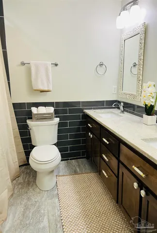 a bathroom with a granite countertop toilet sink and mirror