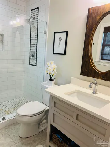 a bathroom with a sink mirror vanity and toilet