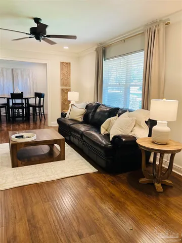 a living room with furniture and a wooden floor