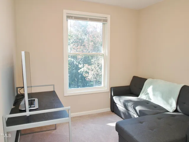 a view of a workspace with furniture and a window