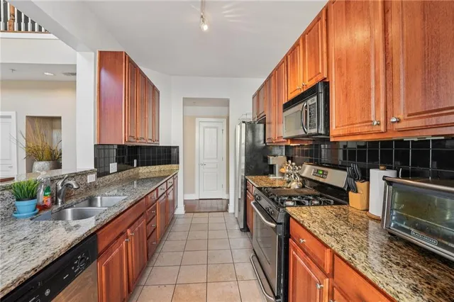a kitchen with stainless steel appliances granite countertop a sink stove and refrigerator