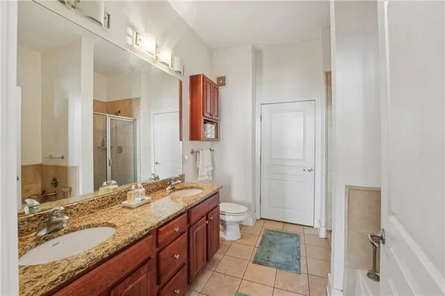 a en suite bathroom with a granite countertop sink and a mirror