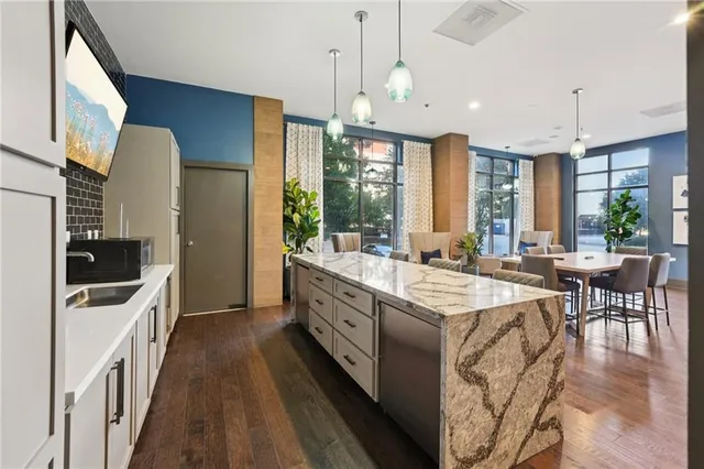 a open kitchen with stainless steel appliances kitchen island granite countertop a sink and a refrigerator