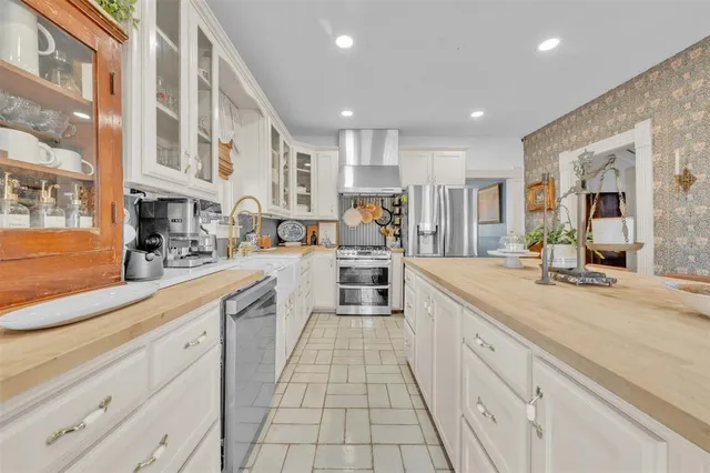 a large kitchen with stainless steel appliances lots of counter space and a sink