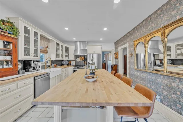 a large kitchen with kitchen island a stove a sink a refrigerator and cabinets