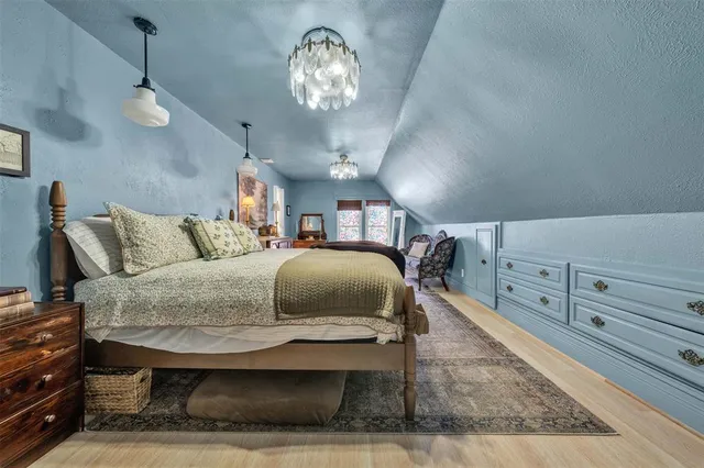 a spacious bedroom with a bed and a chandelier
