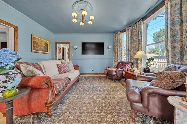 a living room with furniture a chandelier and a flat screen tv