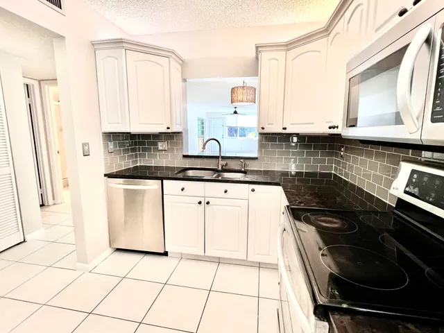 a kitchen with appliances a sink and cabinets