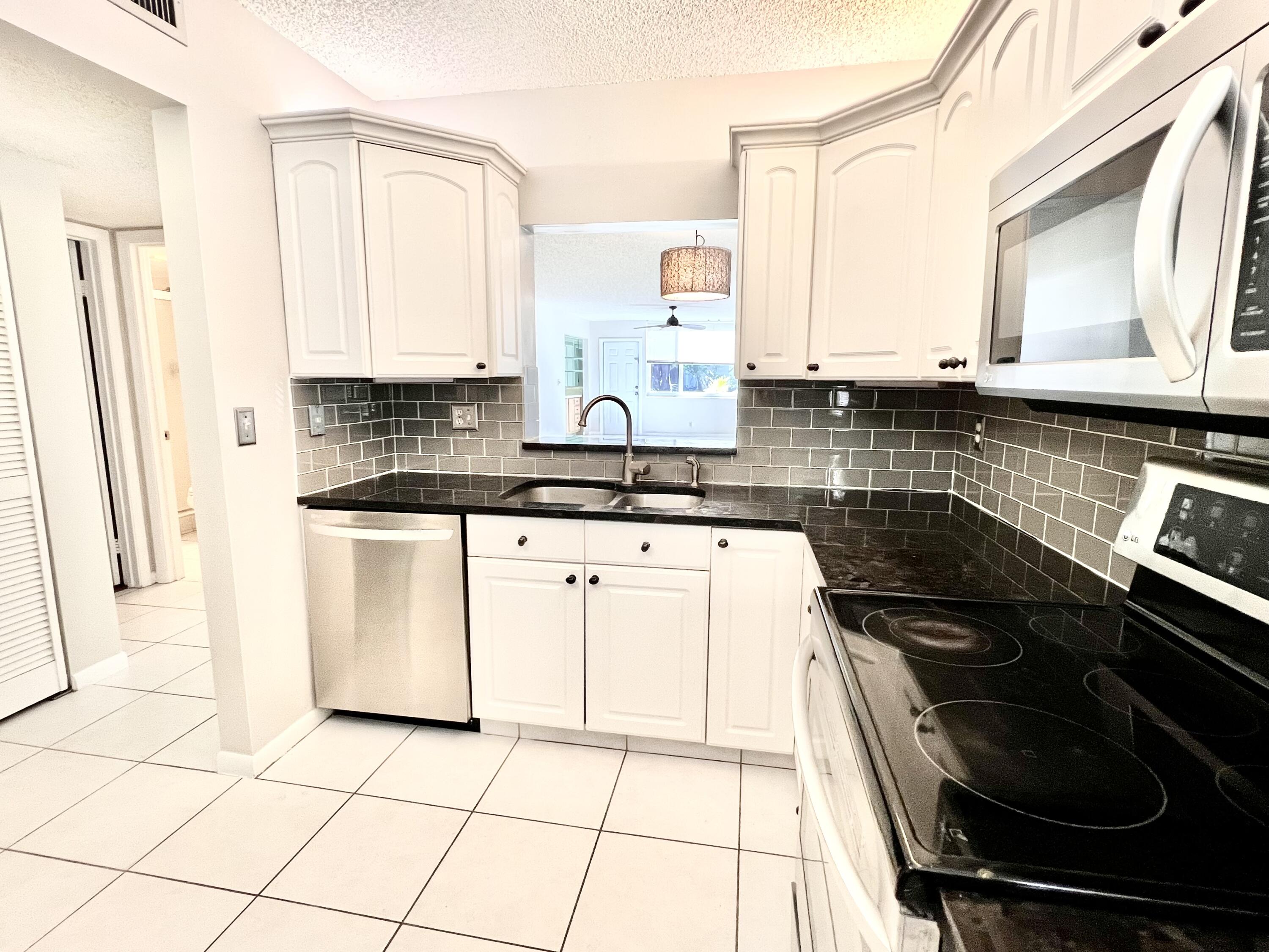 a kitchen with appliances a sink and cabinets