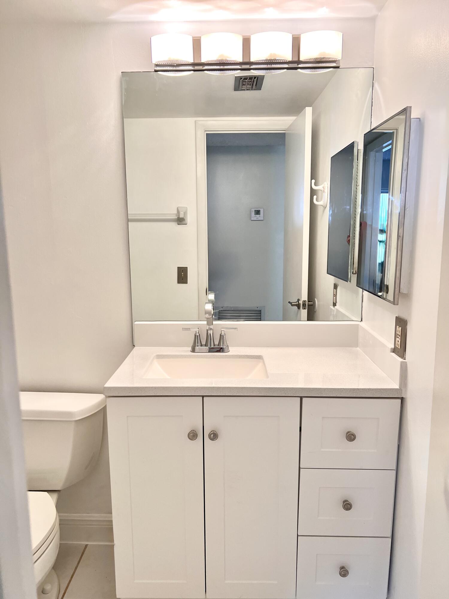 2865 Southwest 22nd Avenue, Unit 108 Delray Beach, FL 33445 - Photo 12 of 16 a bathroom with a sink and a mirror