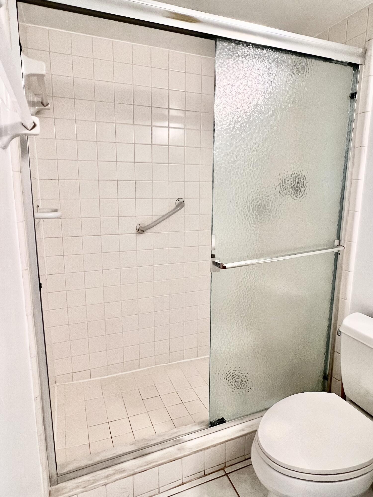 2865 Southwest 22nd Avenue, Unit 108 Delray Beach, FL 33445 - Photo 13 of 16 a white toilet sitting next to a shower