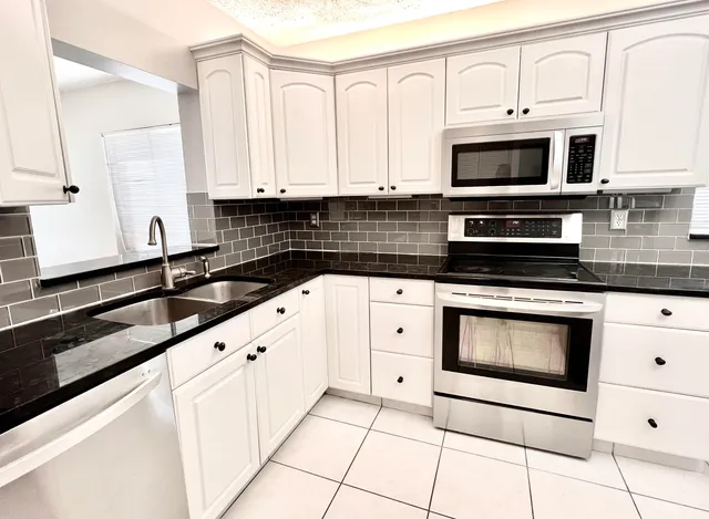 a kitchen with stainless steel appliances a sink stove and cabinets