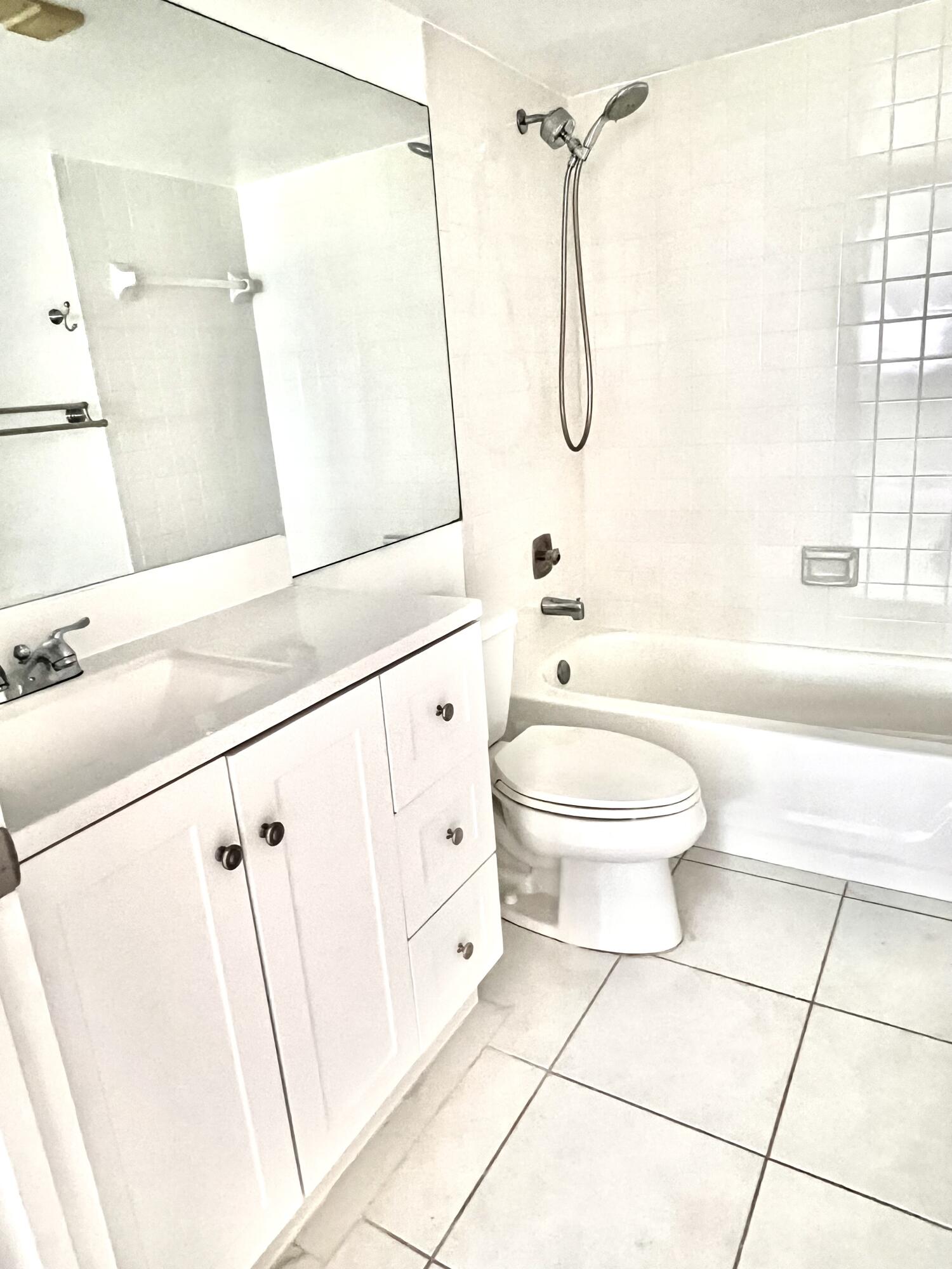 2865 Southwest 22nd Avenue, Unit 108 Delray Beach, FL 33445 - Photo 9 of 16 a bathroom with a granite countertop sink a toilet and shower