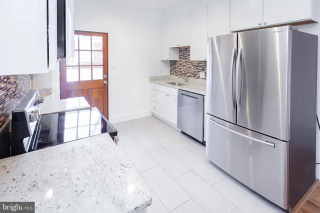 a kitchen with stainless steel appliances a refrigerator sink and cabinets