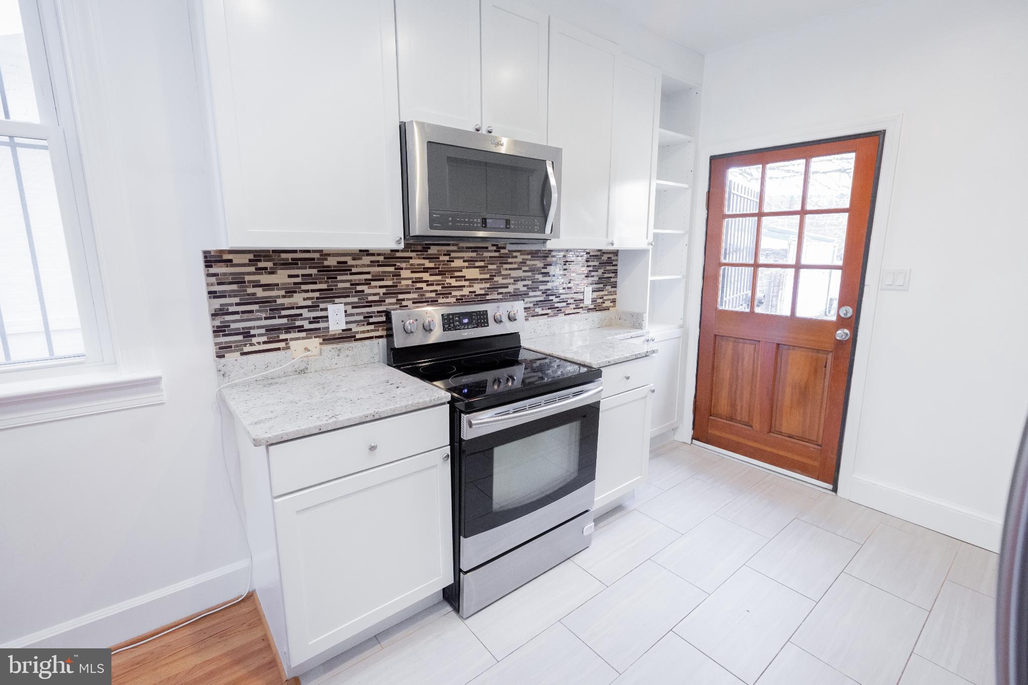 1814 15th Street Northwest, Unit A Washington, DC 20009 - Photo 3 of 15 a kitchen with granite countertop white cabinets and appliances