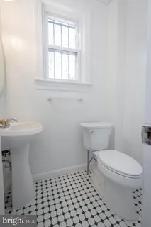 a bathroom with a sink a toilet and a window