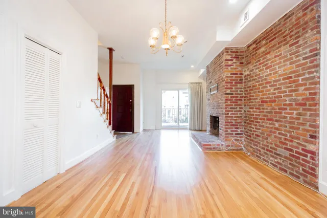 a view of a hallway with wooden floor and a chandelier