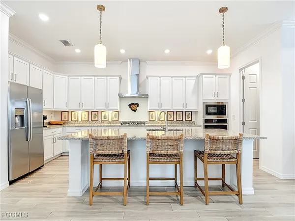 a kitchen with stainless steel appliances kitchen island granite countertop a stove a sink a oven a dining table and chairs