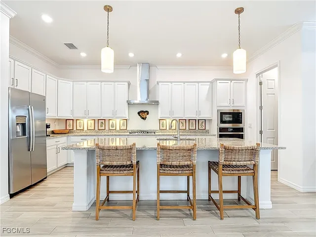 a kitchen with stainless steel appliances kitchen island granite countertop a stove a sink a oven a dining table and chairs