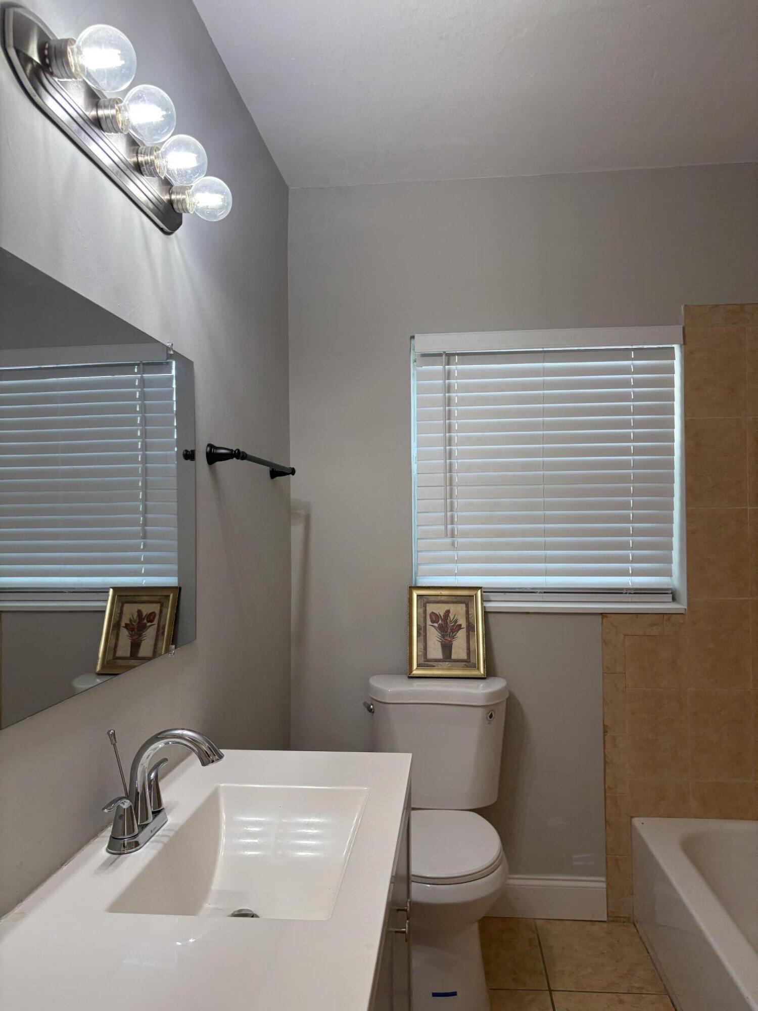 1010 Mayflower Road Fort Pierce, FL 34950 - Photo 11 of 27 a bathroom with a sink a toilet a mirror and shower