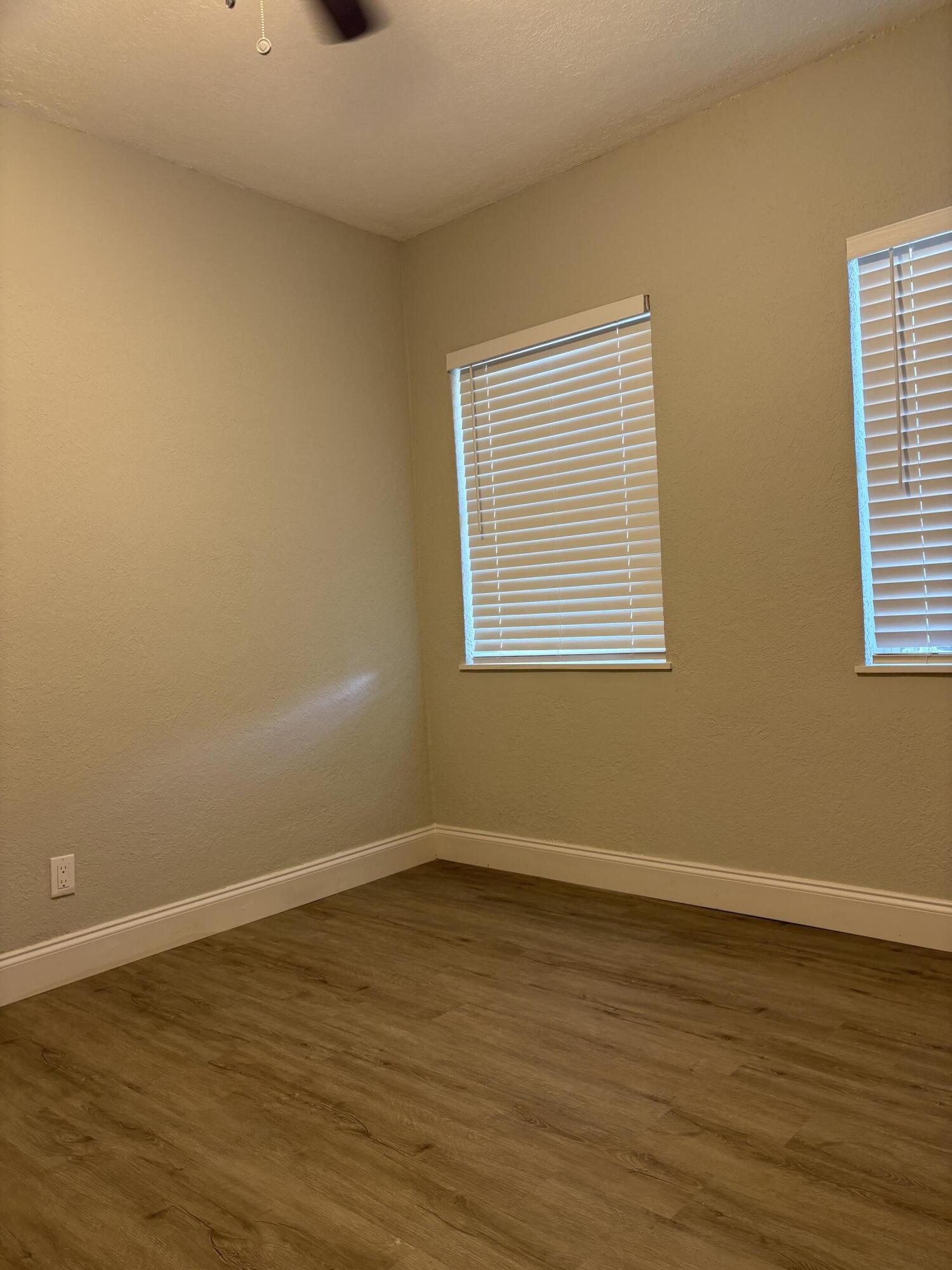 1010 Mayflower Road Fort Pierce, FL 34950 - Photo 10 of 27 a view of an empty room with wooden floor and a window