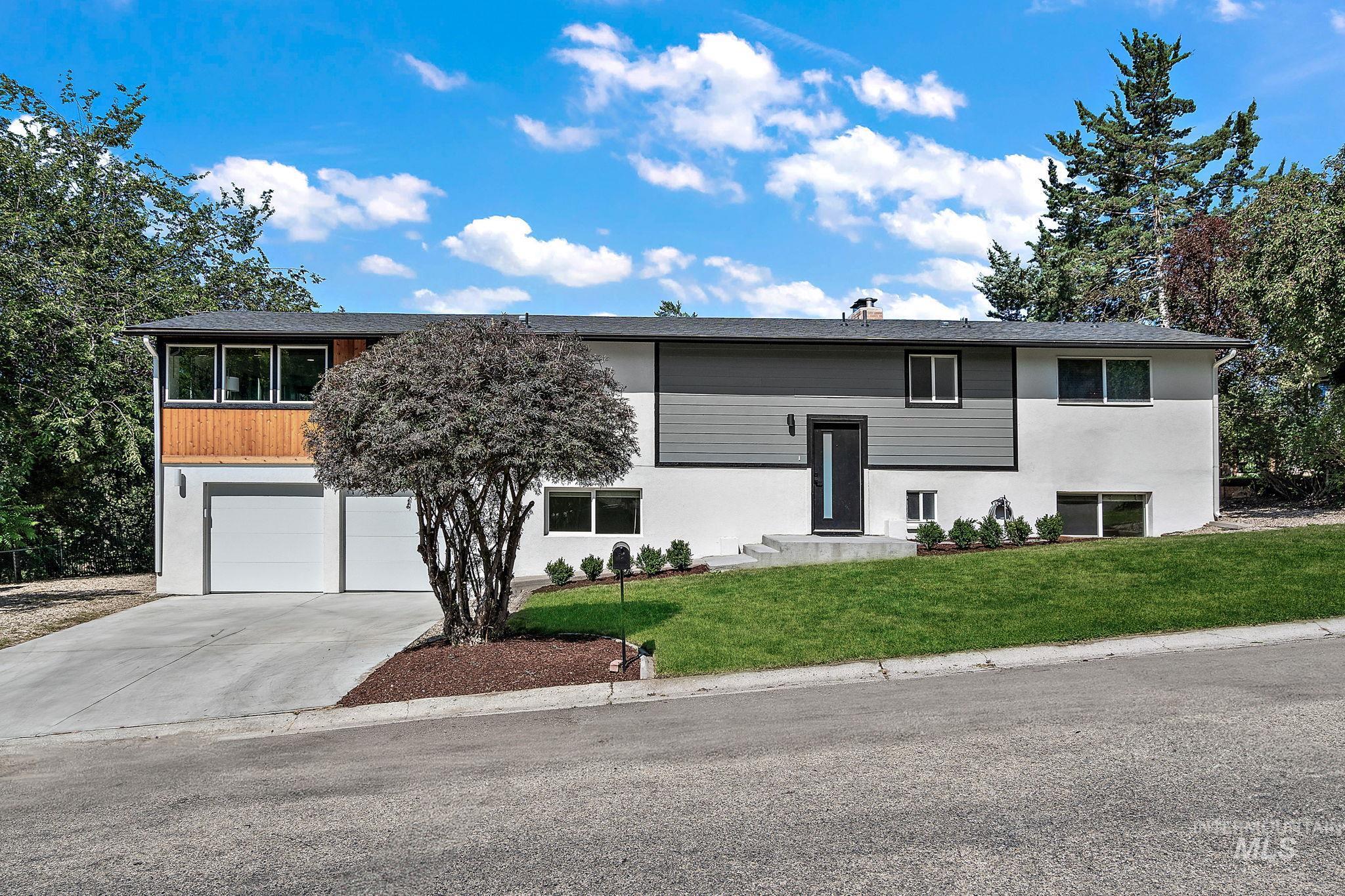 3101 Ridgeway Drive Boise, ID 83702 - Photo 1 of 1 Bi-level home featuring concrete driveway, a garage, a front lawn, and stucco siding
