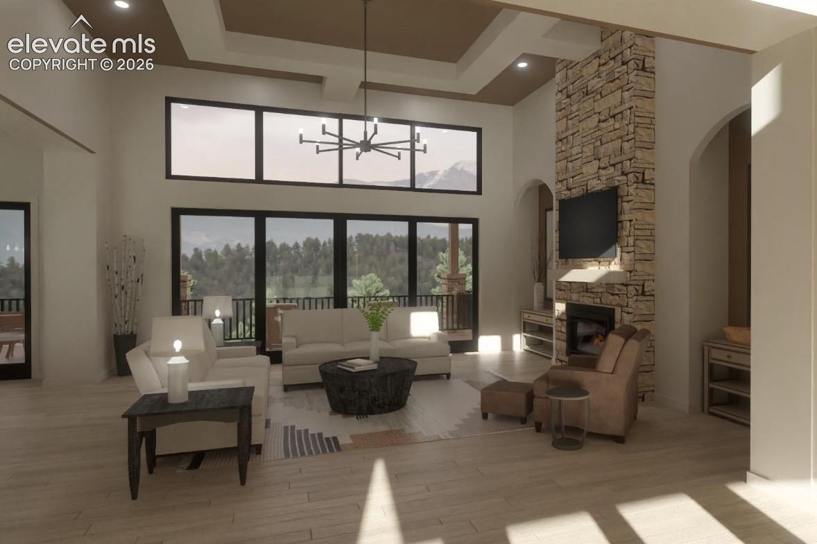 5705 Vessey Road Colorado Springs, CO 80908 - Photo 5 of 19 Expansive living space featuring a high vaulted ceiling, stone fireplace, and large windows with transom panels and wrap around deck