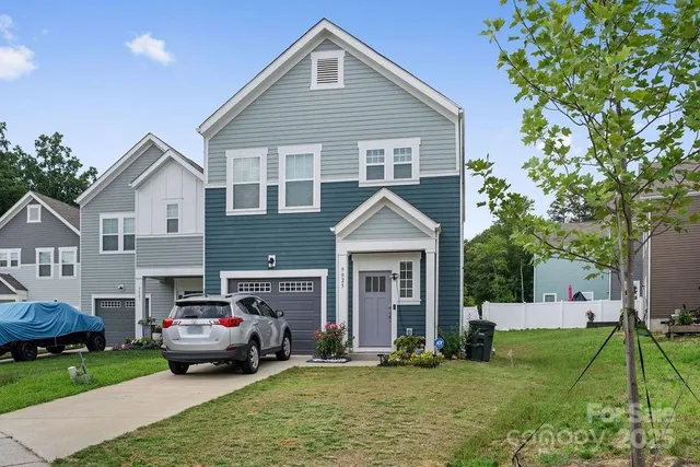 a white house covered with tall trees