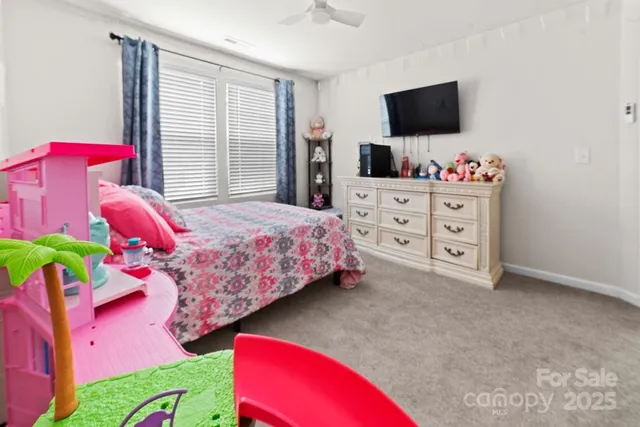 a bedroom with a bed a flat screen tv and a dresser