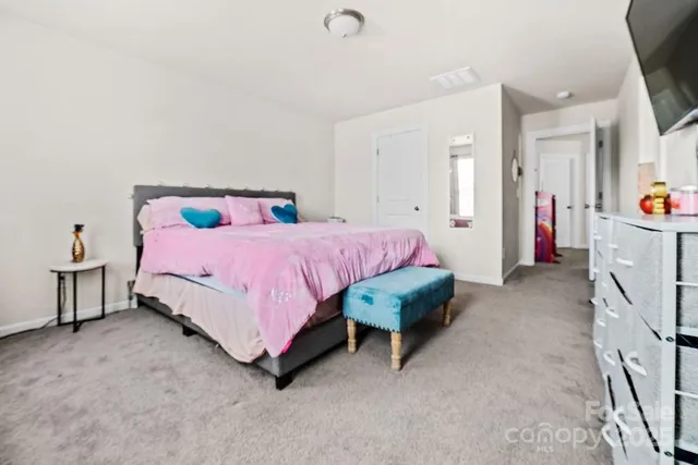 a spacious bedroom with a bed table and a chandelier