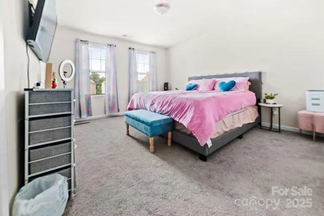 a spacious bedroom with a bed and wooden floor