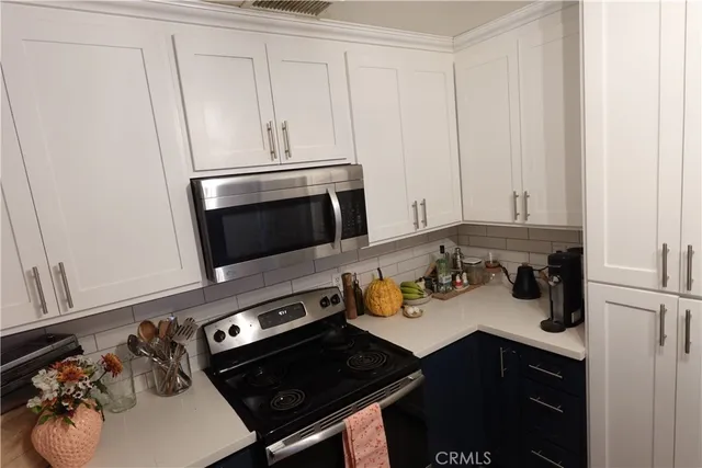 a kitchen with stainless steel appliances a sink stove and cabinets