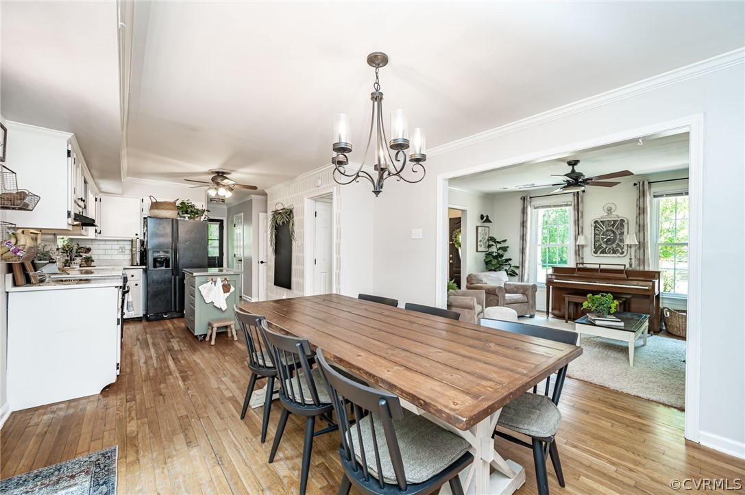 4901 Court Ridge Terrace Midlothian, VA 23112 - Photo 11 of 35 a dining room with wooden floor a chandelier a wooden table and chairs