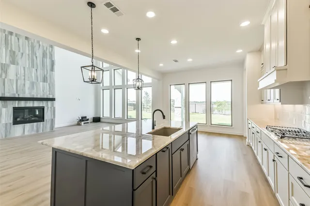 a kitchen with granite countertop a stove and a wooden floor