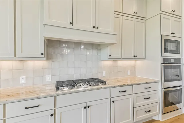 a kitchen with granite countertop white cabinets and white appliances