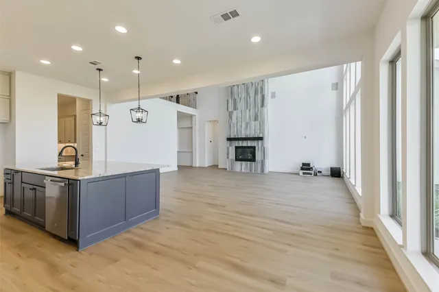 a large kitchen with stainless steel appliances a large counter top a stove and a refrigerator