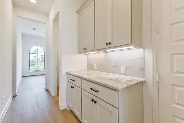 a kitchen with white cabinets and sink