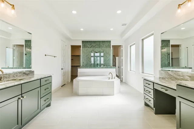 a spacious bathroom with a granite countertop tub double vanity sink and a large mirror