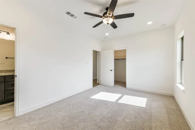 an empty room with closet and fan