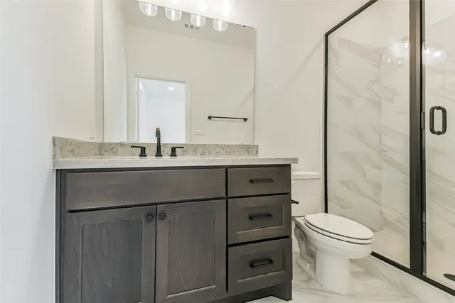 a bathroom with a toilet sink vanity and mirror