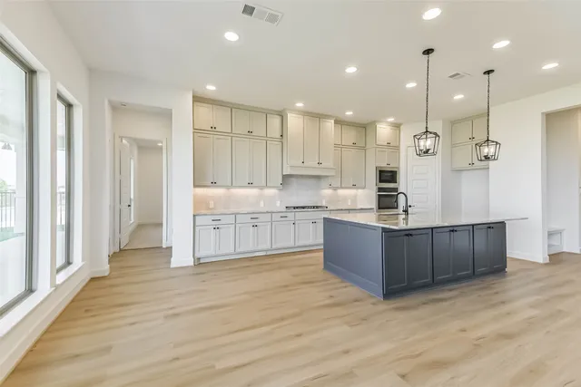 a large kitchen with kitchen island a sink stainless steel appliances and cabinets