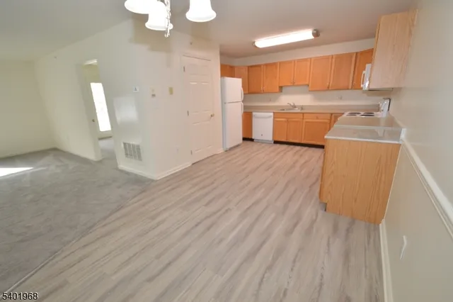a kitchen with wooden floors and white cabinets