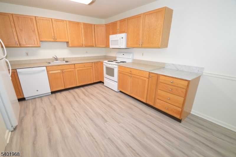 1 Jenny Lind Street, Unit 11 Netcong, NJ 07857 - Photo 23 of 24 a kitchen with wooden floors and white cabinets
