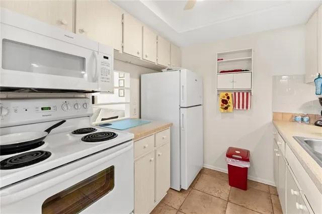 a kitchen with a refrigerator and a stove top oven