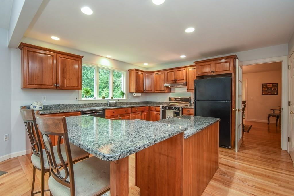 95 Stonefence Road Lunenburg, MA 01462 - Photo 14 of 41 a kitchen with stainless steel appliances granite countertop wooden cabinets a refrigerator and a sink